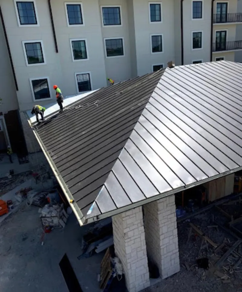 Crew installing standing seam metal roof panels on a commercial project in York